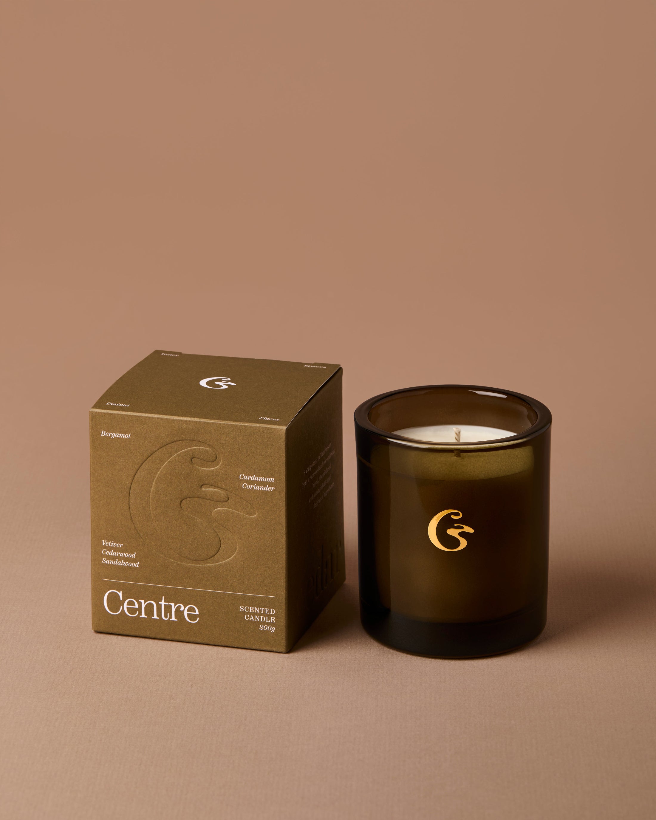 Dark glass candle with a matching box on a brown background, featuring the &