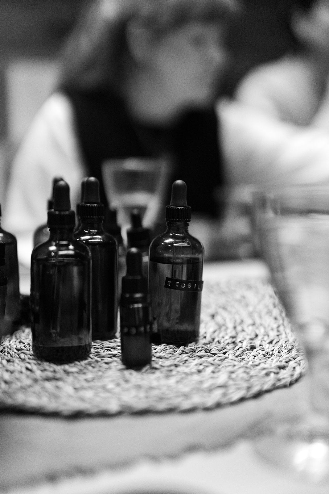 Collection of dark glass bottles with droppers on a textured surface, blurred background