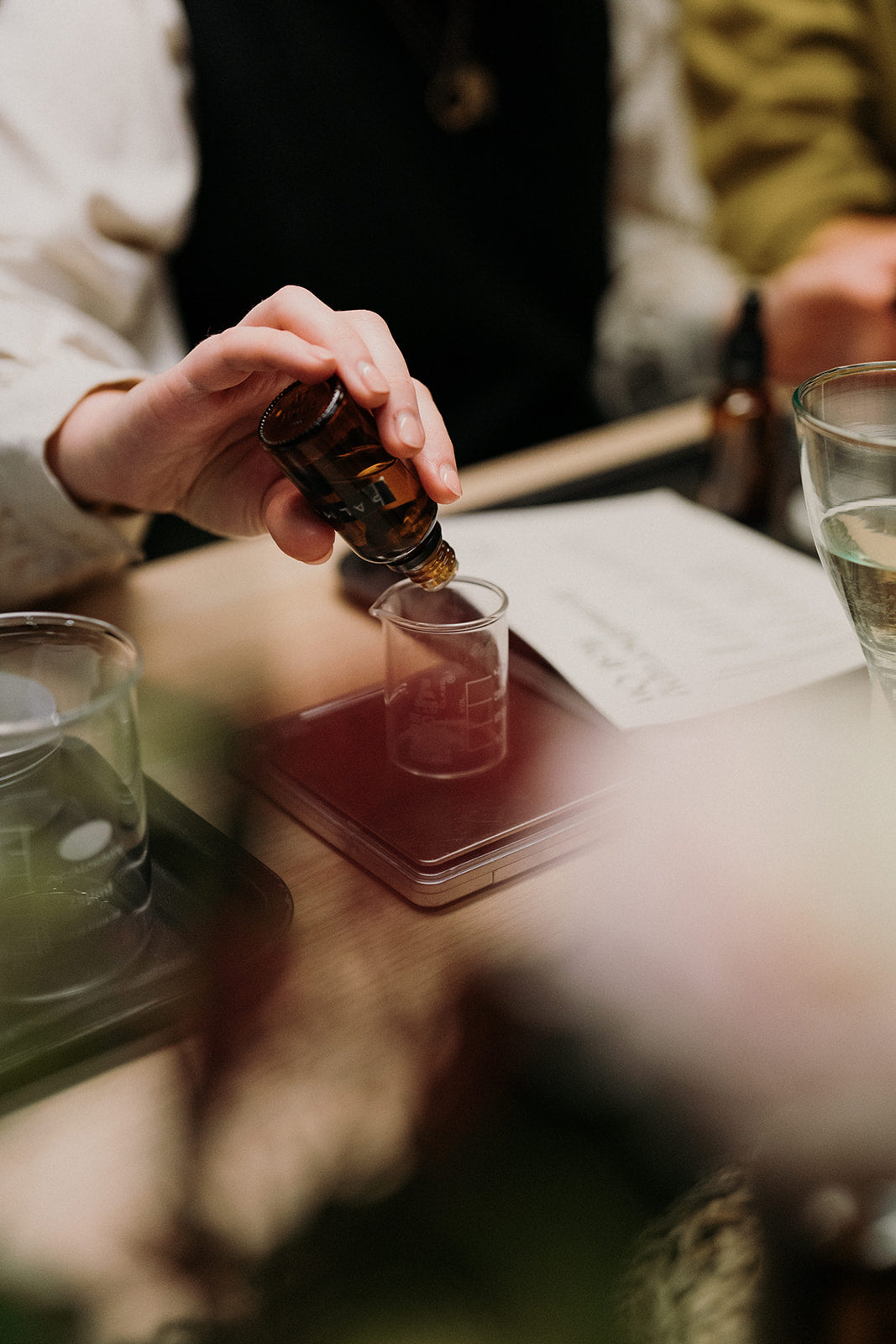 Essential oils being weighed out into a glass beaker. 