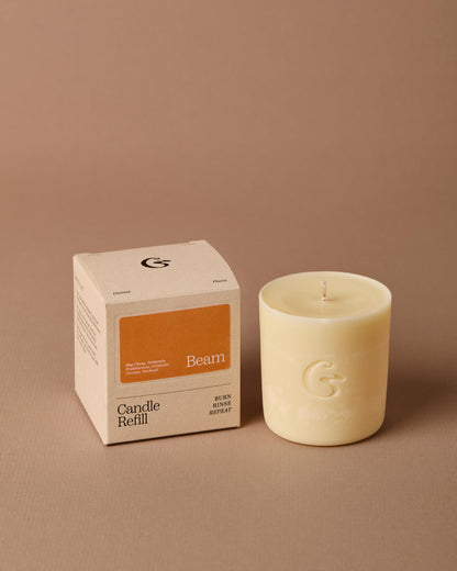 Candle refill and its packaging on a beige background