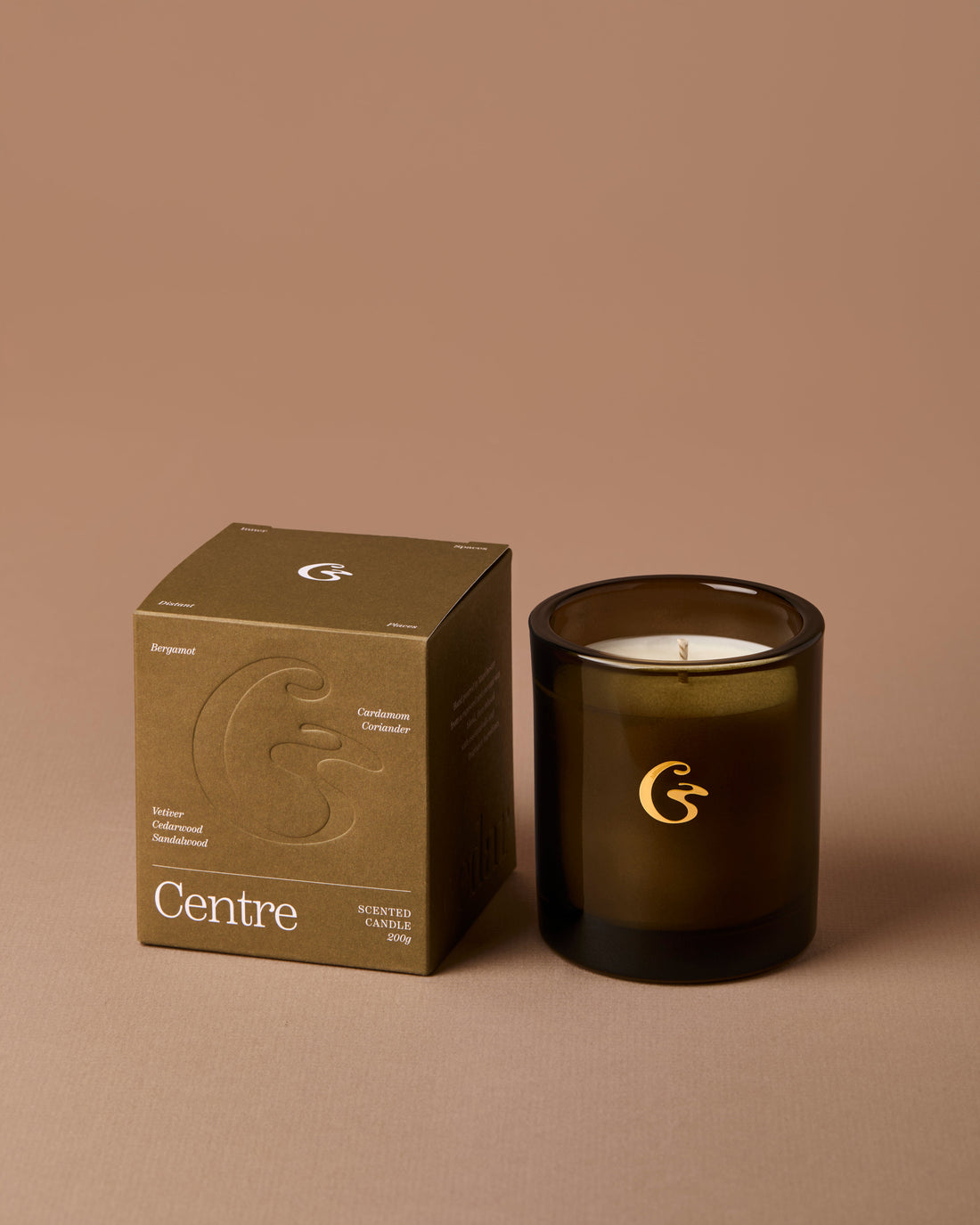 Dark glass candle with a matching box on a brown background, featuring the &