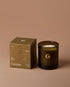 Dark glass candle with a matching box on a brown background, featuring the &