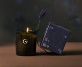 Candle with a lit wick and packaging on a dark background with the name eve