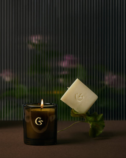 Candle with a floating candle refill and logo on a dark background