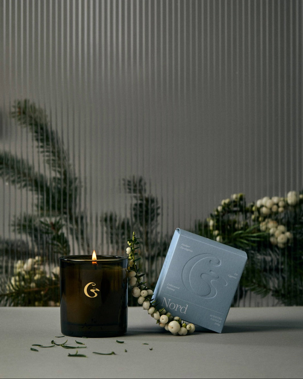 Candle with a decorative box on a surface with a blurred background