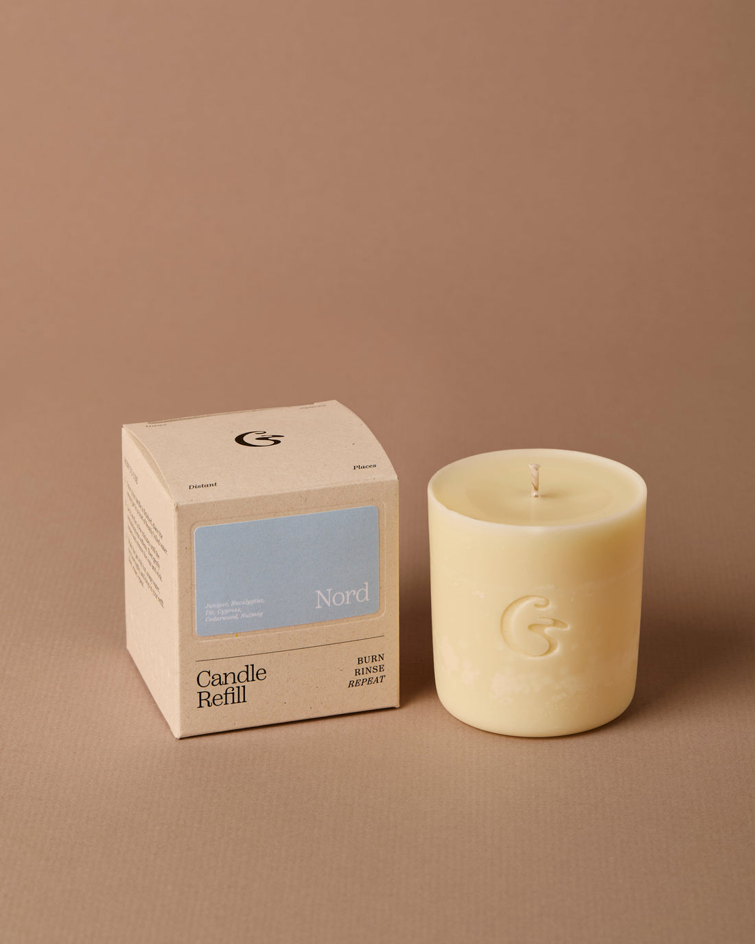 Candle and its packaging on a brown background