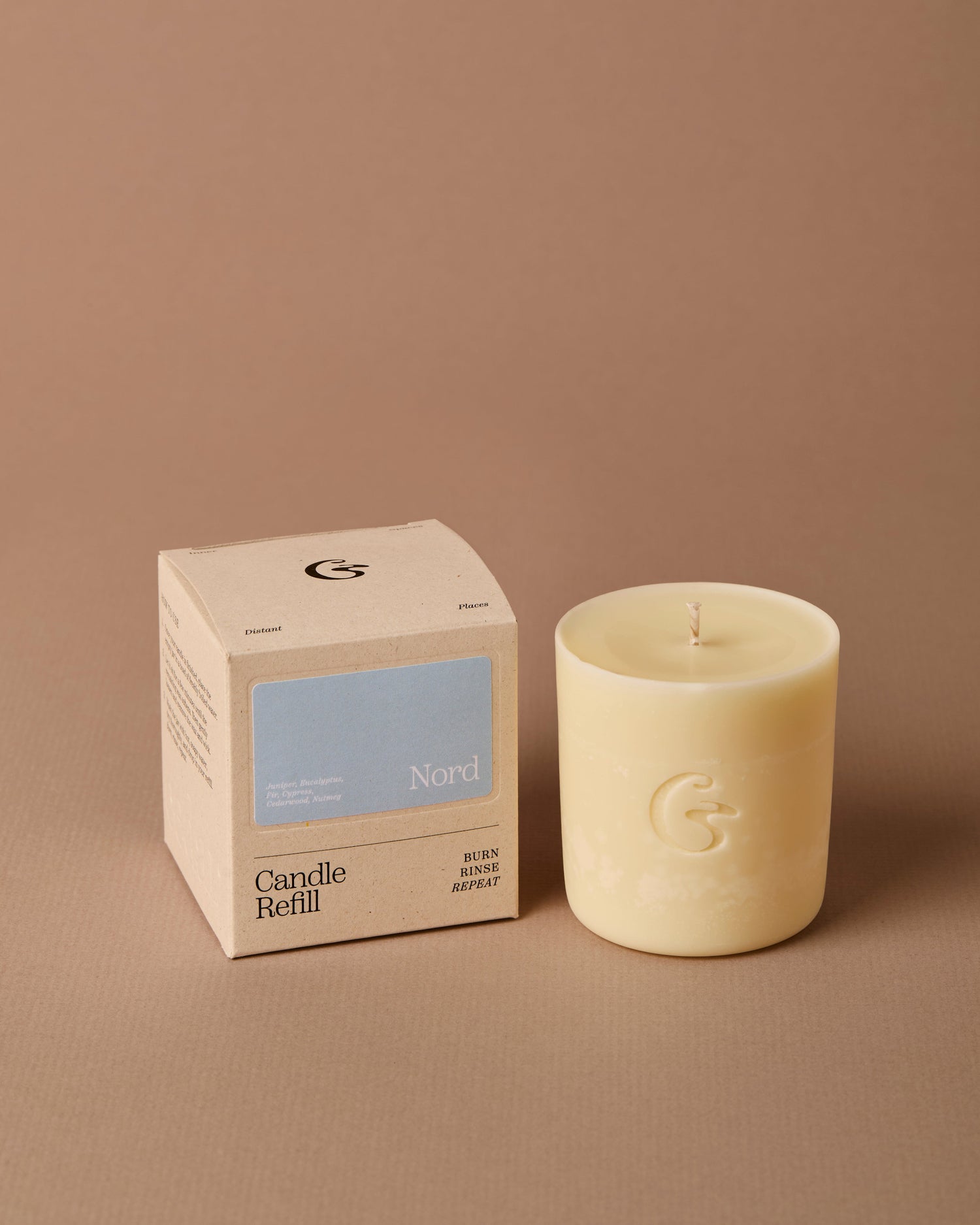 Candle and its packaging on a brown background