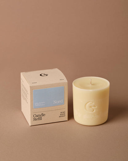 Candle and its packaging on a brown background