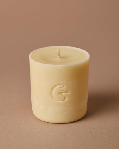 Candle refill with embossed cedar logo. Set against a beige background